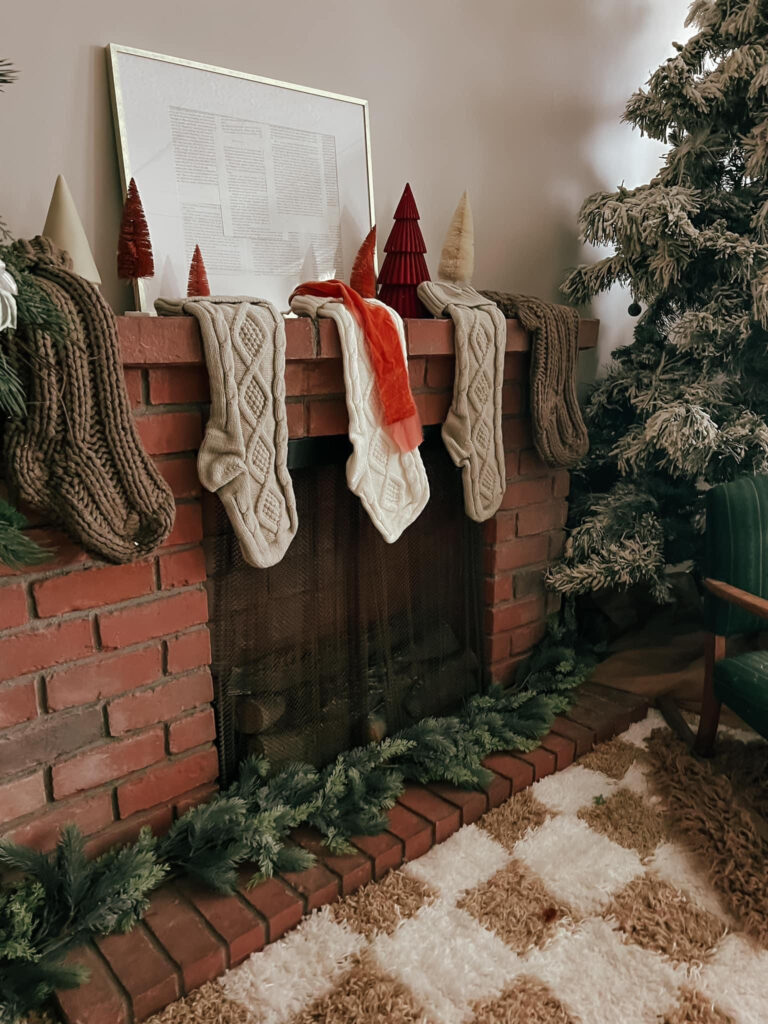 Cozy Christmas fireplace with stockings and decorations.