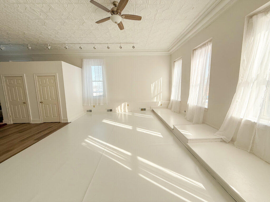 Bright room with white walls and ceiling fan.